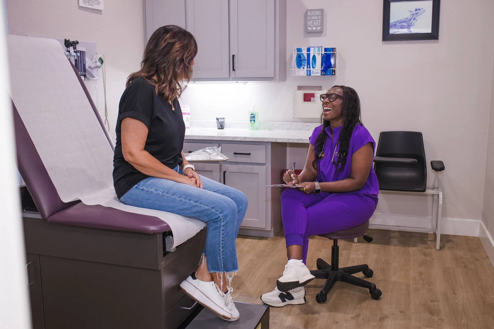 A JM Wellness provider consulting with a patient in an exam room
