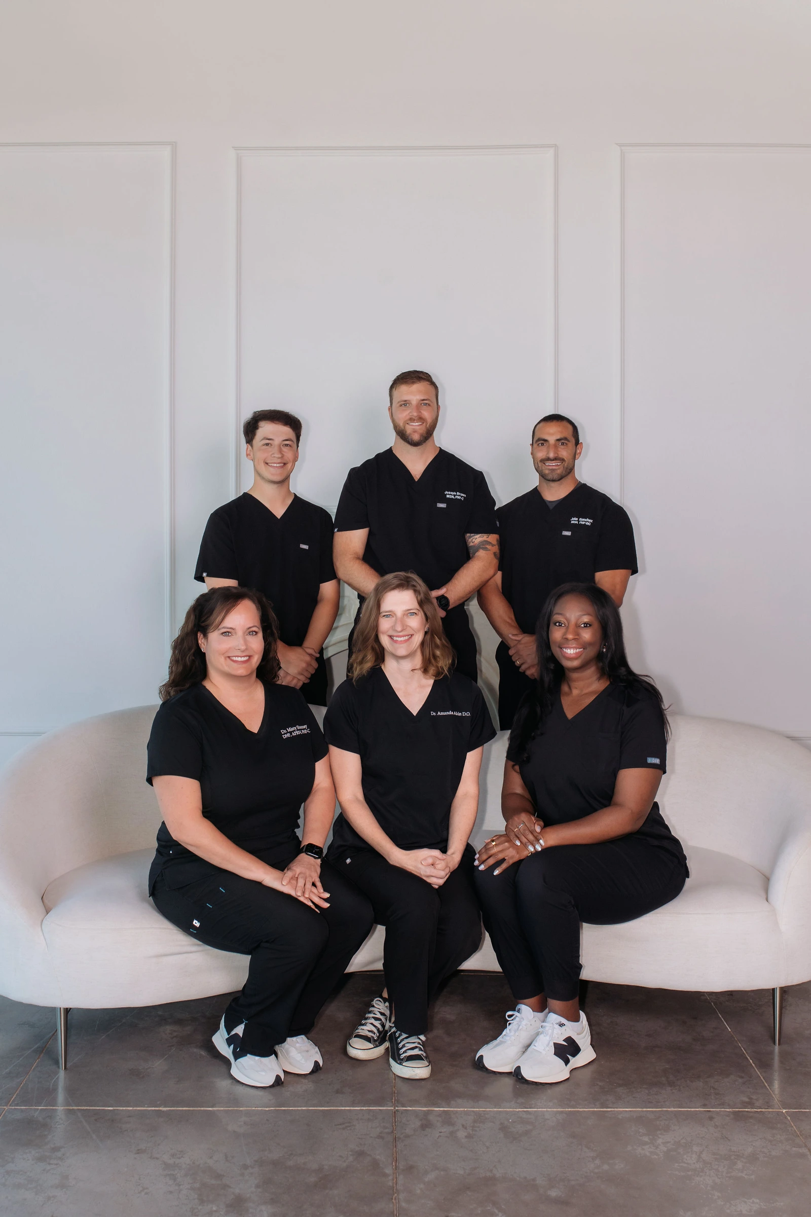 All six JM Wellness providers, with Joe and Dr. Amanda Akin in the center