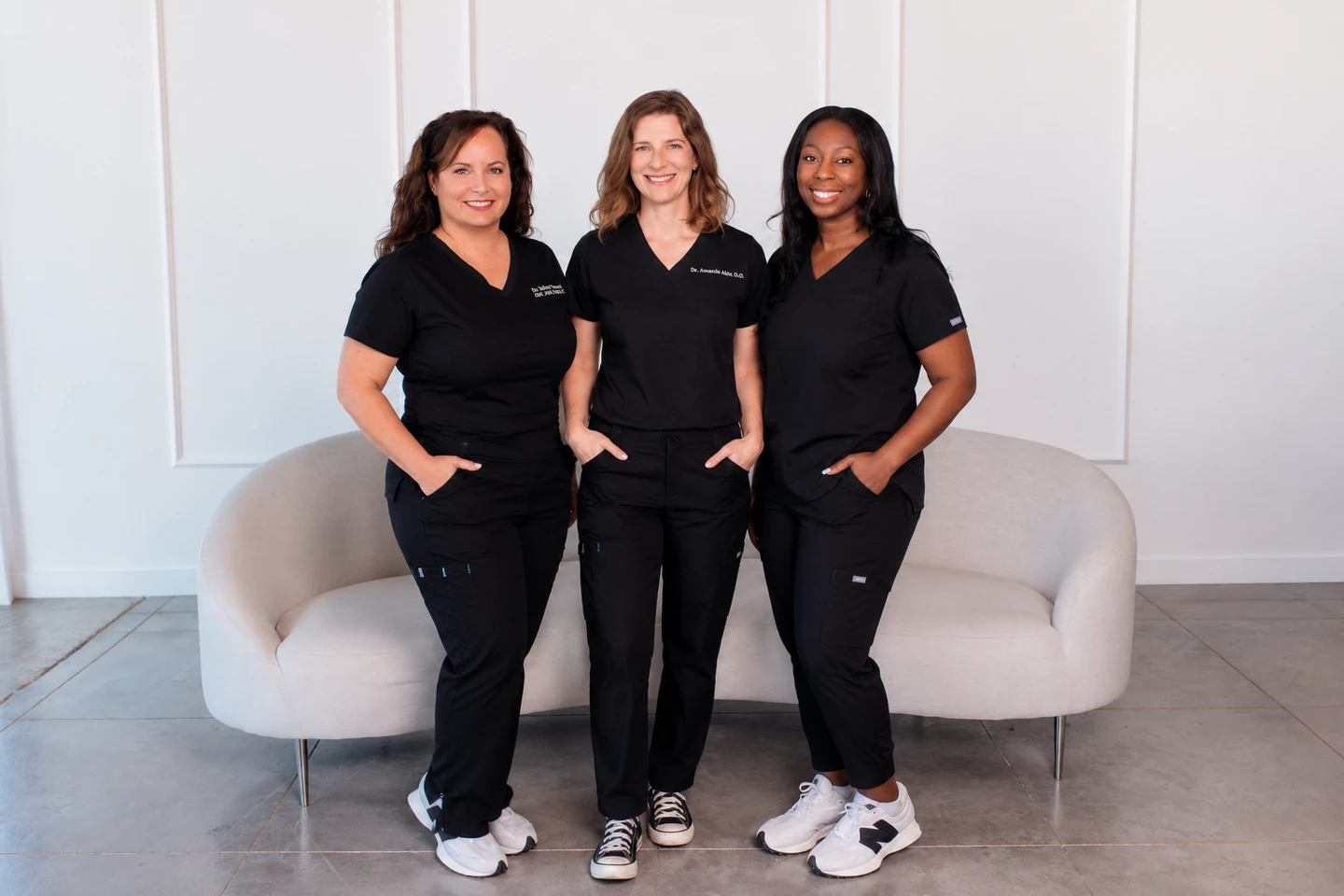 Three JM Wellness providers standing together in the clinic